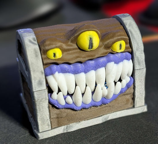Close-up of the Moving Mimic treasure chest with three yellow eyes, purple gums and white teeth.